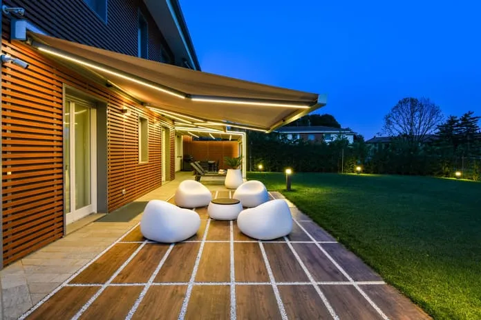 Retractable awning over a wooden deck at dusk